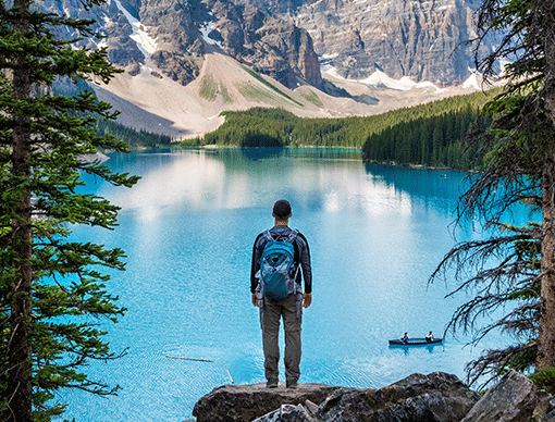 man hiking in front of lake