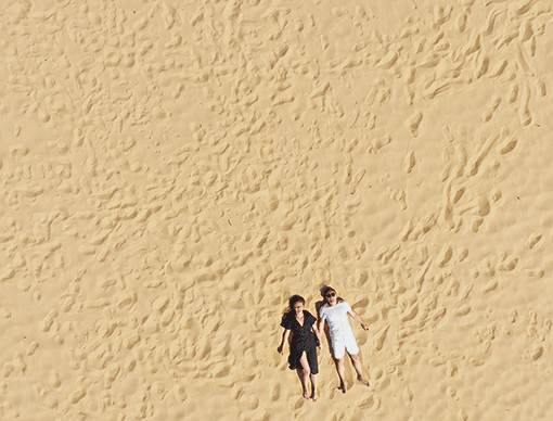 couple laying on sand