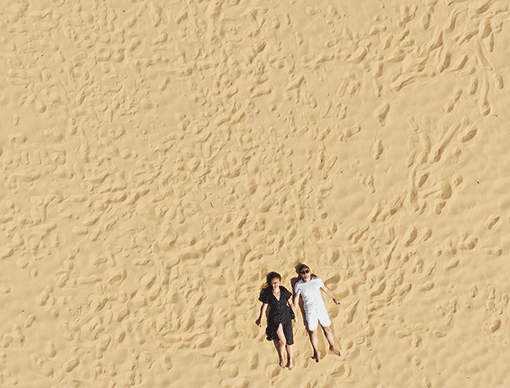 couple laying on sand couple laying on sand
