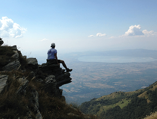 hiker sitting on ledge hiker sitting on ledge