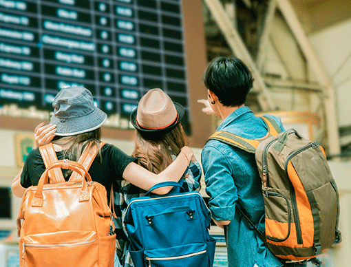 group of friends looking at airport time boards group of friends looking at airport time boards