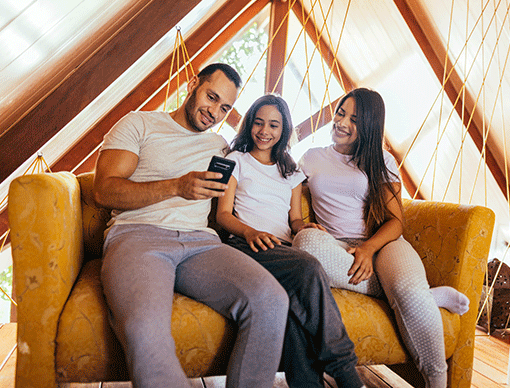three individuals look at a phone three individuals look at a phone