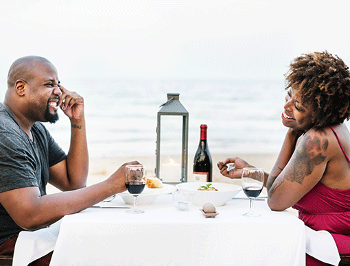 man and woman eating on a beach man and woman eating on a beach