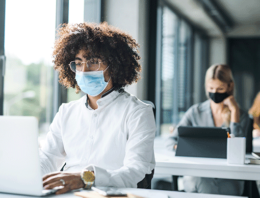 people at computers with masks on people at computers with masks on